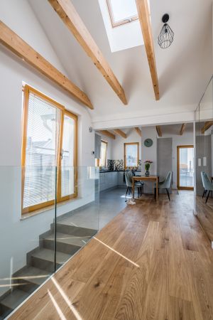 szerokie-deski-drewniane-podlogowe-w-wysokim-mieszkaniu-z-belkami