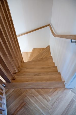schody-drewniane-debowe-z-bialymi-podstopniami-i-drewniana-azurowa-balustrada-02